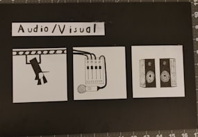 A black and white graphic depicting lights, a sound board, and speakers